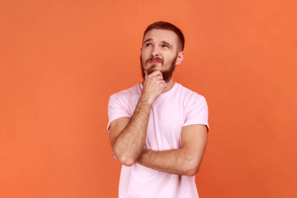 istock Thoughtful man holding his chin and pondering idea, confused not sure about solution. 1366752454