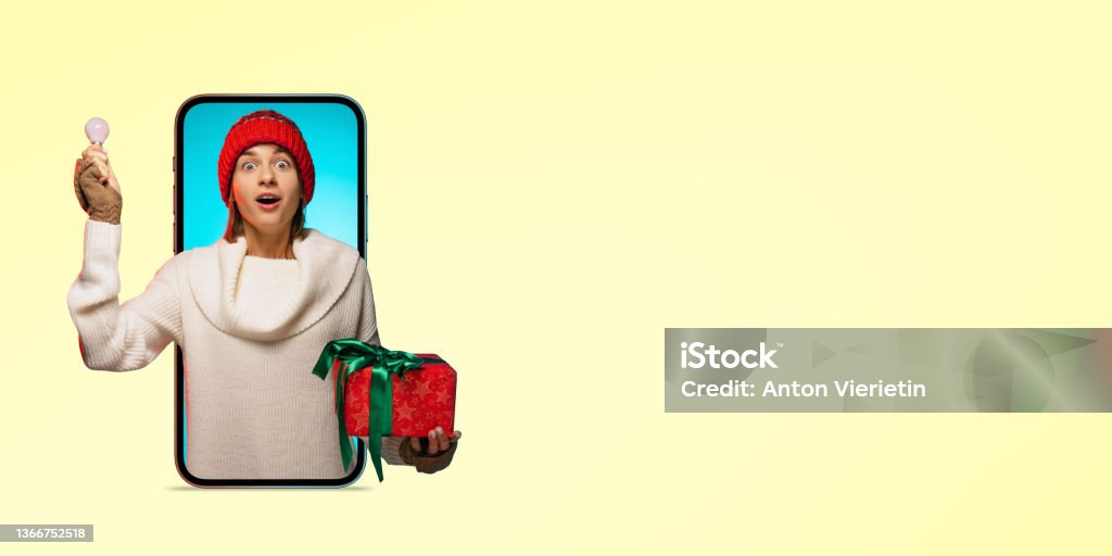 Creative collage. Young cheerful girl with present box and lighbulb sticking out tablet screen symbolizing present ideas Collage. Young cheerful girl with present box and lighbulb sticking out tablet screen symbolizing present ideas. Communication via Internet. Concept of holidays, network support, online shopping 20-24 Years Stock Photo