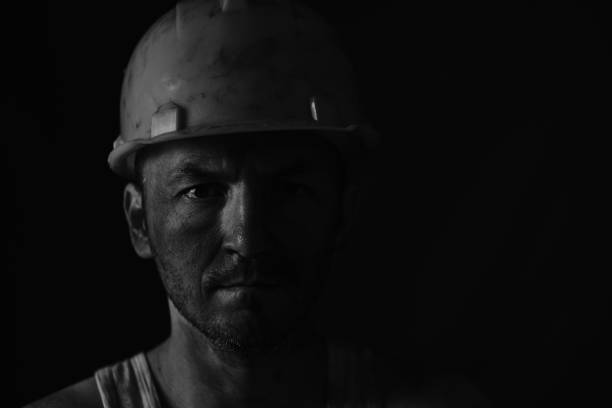 istock Portrait miner in helmet and undershirt with dirty face. 1366752727