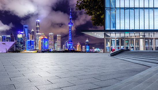 Panoramic skyline and modern commercial buildings with empty square floor in Shanghai at night, China. empty road and cityscape.