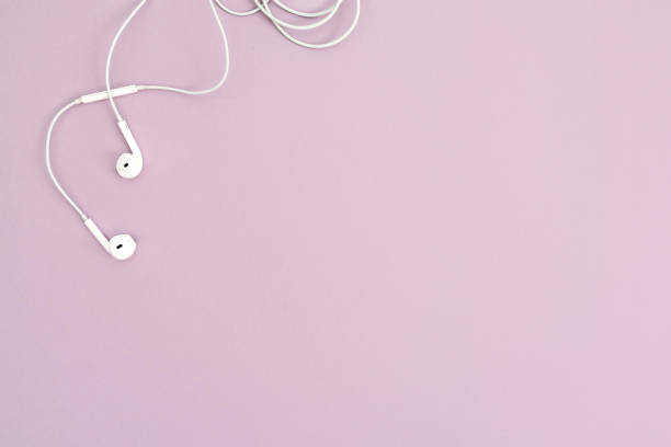 Minimalistic top view with white headphones on pastel background