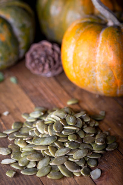 istock Raw pumpkin seeds and pumpkin in the back. 1366755507
