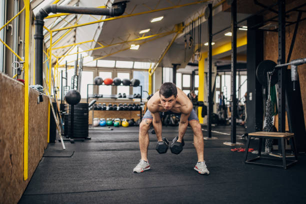 istock Man exercising with dumbbells in gym 1366758169