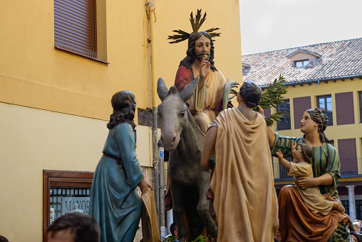 Jesus Christ mounted on a donkey, in procession during the Holy Week of Tordesillas, there are also figures of people cheering, it is the procession of the Christian Palm Sunday.