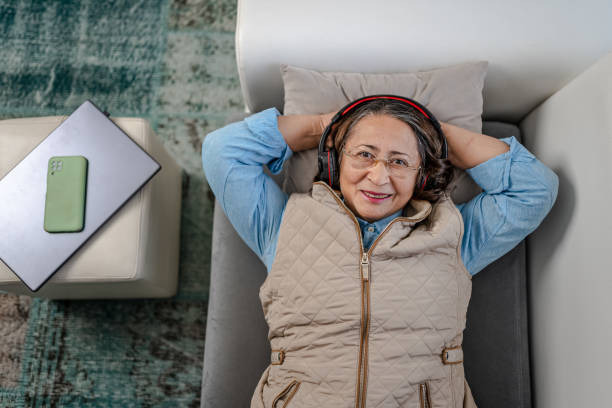istock Relaxed Senior Woman lying on couch and looking at camera 1366759930