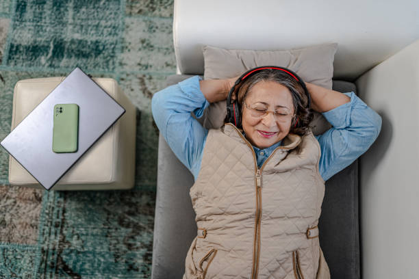 istock Relaxed Senior Woman lying on couch  after work 1366759958