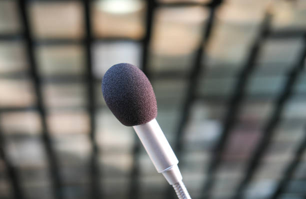 istock Close-up of a microphone from a low angle view in a conference hall or boardroom, selective focus 1366761013