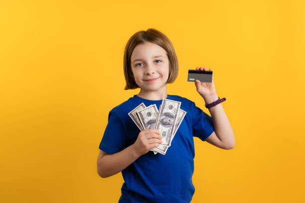 Child Showing Dollars and credit card stock photo
