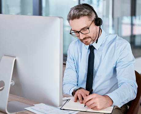 Call Note Agent Shot Of A Mature Call Centre Agent Writing Notes While Working On A ...