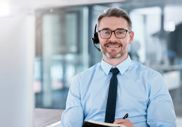 istock Portrait of a mature call centre agent writing notes while working on a computer in an office 1366763748