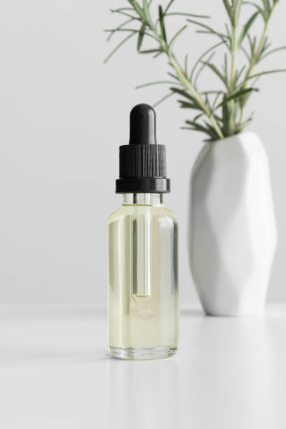 istock Dropper bottle mockup with a rosemary on the white table. 1366765859