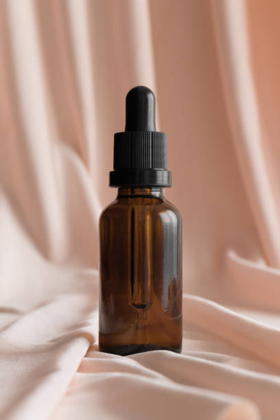 istock Dropper bottle mockup on the soft pink textile. 1366766577