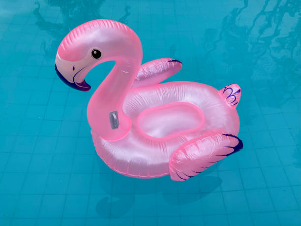 Pink flamingo inflatable float in blue pool.