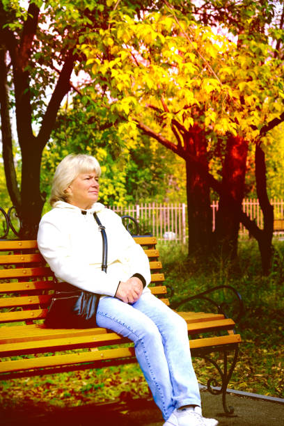 istock Senior Woman Relaxing On Park Bench. Toned 1366769667