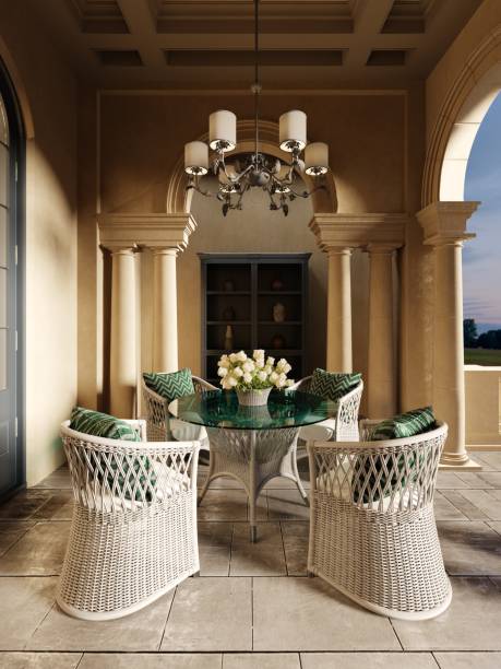 istock A wicker dining table with glass top and wicker chairs on a pillared terrace in the evening sun. 1366770854