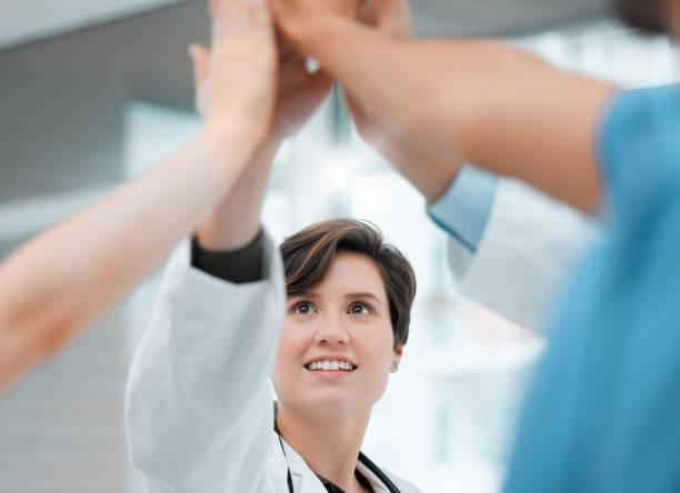 istock Shot of a group of doctors giving each other a high five at work 1366772075