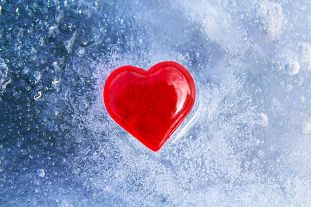 istock Red glass heart on blue ice. Close-up. Top view. Background. Texture. 1366773209