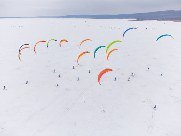 SnowKiting kitesurfing sport on the ice lake winter. Aerial drone view. stock photo