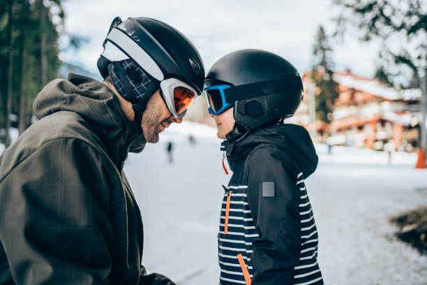 padre e hijo en vacaciones de invierno en la montaña. - skiing snow skiing helmet fun fotografías e imágenes de stock