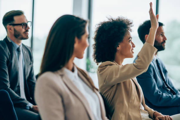 la empresaria quiere hacer una pregunta en un seminario. - seminar asking business meeting fotografías e imágenes de stock