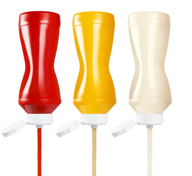 ketchup, moutarde et mayonnaise sortant des bouteilles en plastique sur du blanc - gicler photos et images de collection