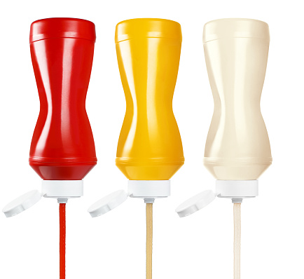 Ketchup, mustard and mayonnaise squeezing out of plastic bottles, isolated on white background