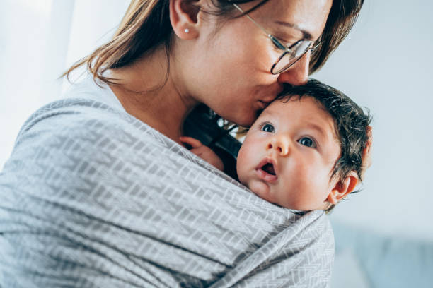 istock Mother kissing her son in sling. 1366778240