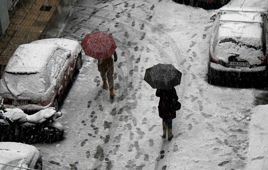 People walking on snow and ice after heavy snowfall, Athens, Greece, January 24 2022.