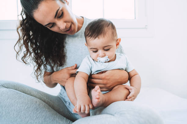 istock Young mom having fun with her son in bed at home - Focus on baby face 1366781049