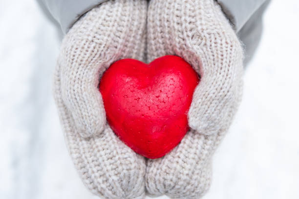 istock hands in mittens holding a red heart 1366783127