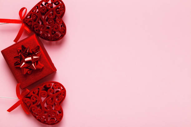 istock Two red valentine hearts and a gift box on a pink background with space for text and copy space. 1366783280