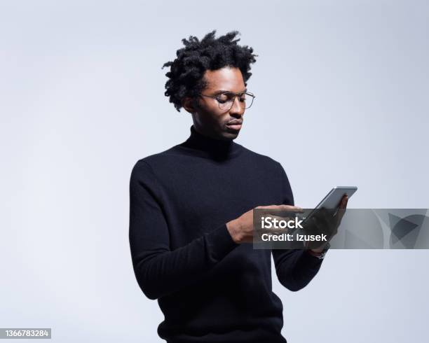 Young Man In Black Turtleneck Using Digital Tablet Stock Photo - Download Image Now - Digital Tablet, Studio Shot, Men