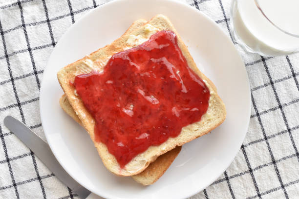 Toast with raspberry jam and butter on a plate. Toast with raspberry jam and butter on a plate.  Lovely breakfast at home.  Food from above concept. raspberry jam stock pictures, royalty-free photos & images