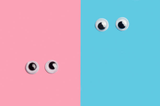Toy eyes on a pink and light blue background with copy space