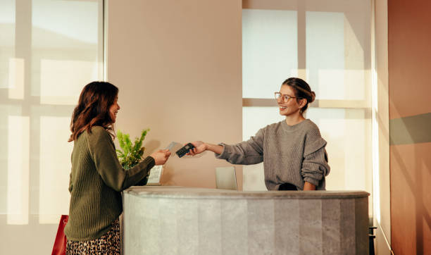 istock Cheerful shop assistant taking a card payment from a female customer 1366784683