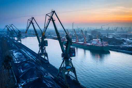 Scenery of port cranes by the Martwa Wisla river at sunset, Gdansk. Poland.