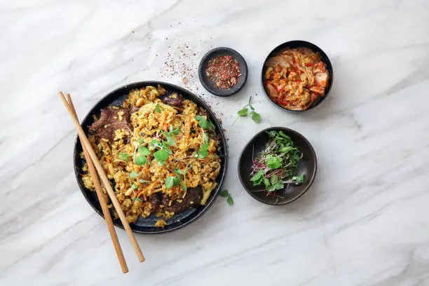 Thai Beef Fried Rice. Flat lay top-down composition on marble background.