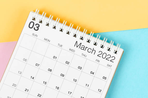 March 2022 desk calendar on multicolored background.