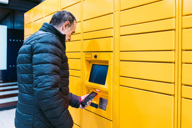 istock Man in coat scans a code on the mobile phone to pick up a package from the yellow locker. Messaging concept, compare online, e-commerce and packages 1366786207