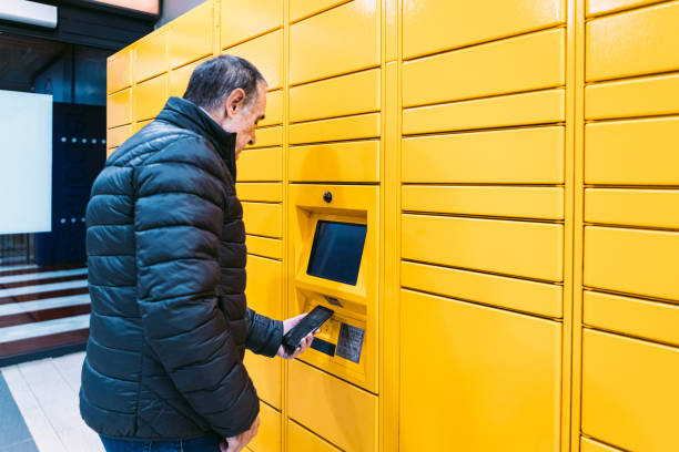 istock Man in coat scans a code on the mobile phone to pick up a package from the yellow locker. Messaging concept, compare online, e-commerce and packages 1366786277