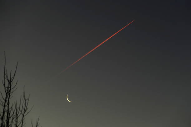 Bavaria, Germany. Jet Stream with waning crescent moon at Sunrise.