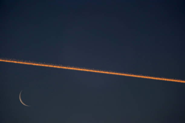 Bavaria, Germany. Jet Stream with waning crescent moon at Sunrise.