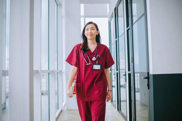 asiatische chinesische krankenschwester lächelt auf dem flur des krankenhauses - female nurse nurse scrubs female doctor stock-fotos und bilder