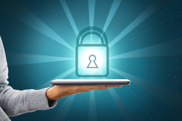 istock Close up of hand holding tablet with glowing padlock on coding background. Digital safety, security, antivirus and protection concept. 1366792731