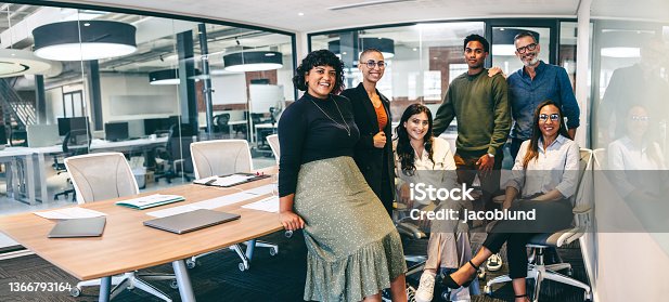 istock Team of businesspeople smiling at the camera in a boardroom 1366793164