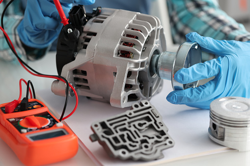 Master repairman diagnosing breakdown of car generator using tester closeup. Car repair service concept