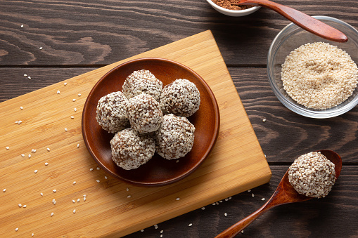 Energy balls on cutting board with spice on wooden background