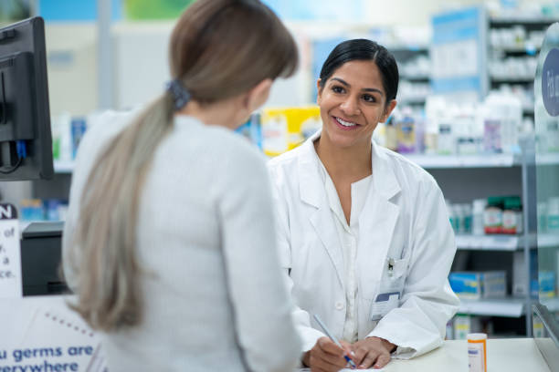 istock Pharmacist Reviewing a New Medication with a Customer 1366795626