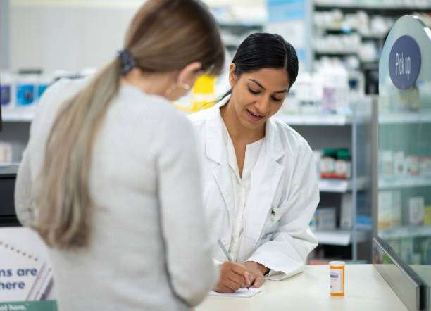 istock Pharmacist Reviewing a New Medication with a Customer 1366795635