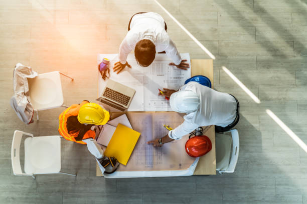 visão superior da construção e estrutura da equipe criativa engenheiro ou reunião de arquitetos para projeto que trabalha com parceiro e ferramentas sobre construção de modelos e projeto em local de trabalho - safety meeting construction site construction - fotografias e filmes do acervo